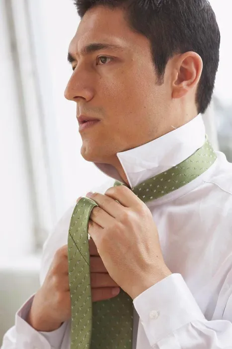 Framed Print : Side profile of a businessman tying his tie Framed Print : Side profile of a businessman tying his tie