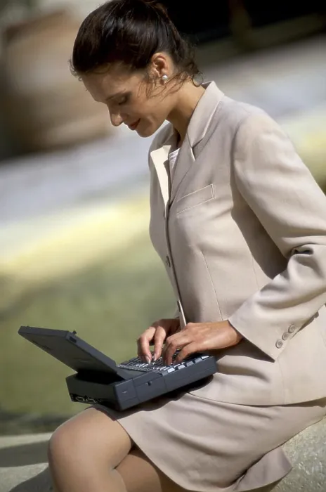 Framed Print : Side profile of a businesswoman sitting using a laptop Framed Print : Side profile of a businesswoman sitting using a laptop