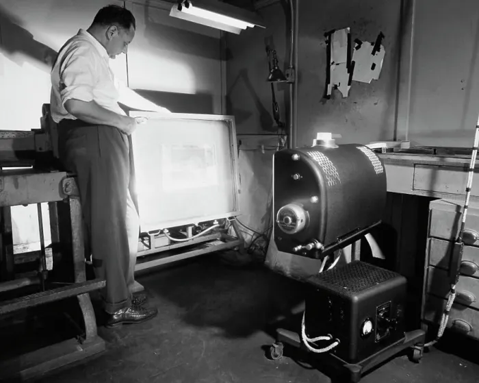 Framed Print : Side profile of a male worker operating a photoengraving camera Framed Print : Side profile of a male worker operating a photoengraving camera