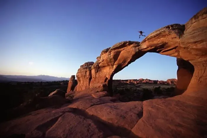 Framed Print : Side profile of a man leaping on a natural arch, Arches National Park, Utah, USA Framed Print : Side profile of a man leaping on a natural arch, Arches National Park, Utah, USA