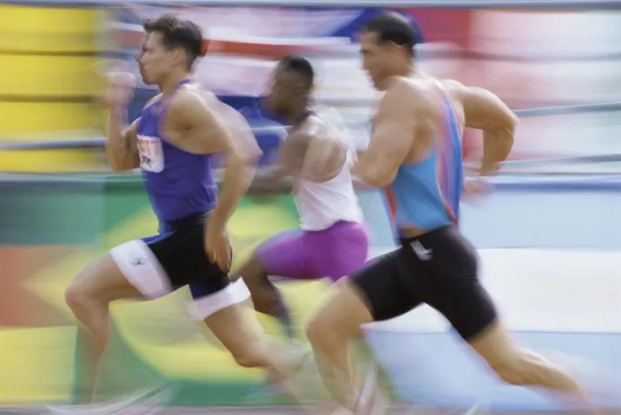 Framed Print : Side profile of three men running on a running track Framed Print : Side profile of three men running on a running track