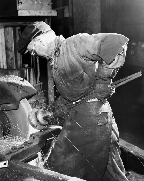 Framed Print : Side profile of a senior man working on a machine in a factory Framed Print : Side profile of a senior man working on a machine in a factory