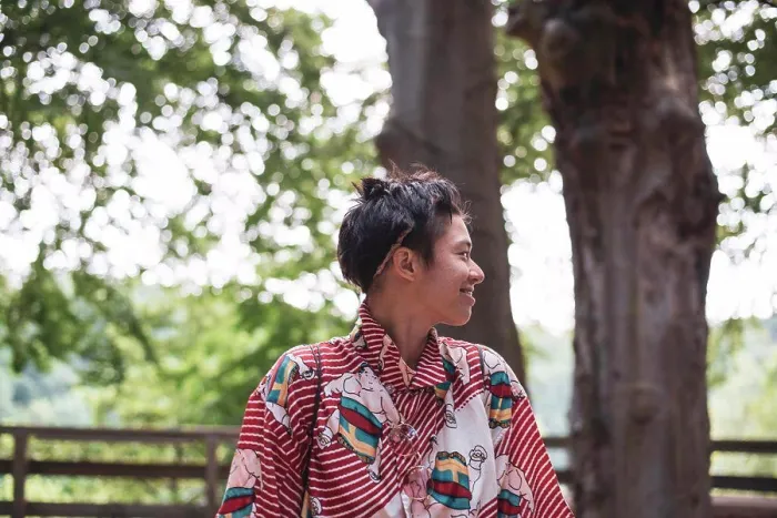 Framed Print : Profile of smiling non-binary adult in colourful shirt in forrest Framed Print : Profile of smiling non-binary adult in colourful shirt in forrest