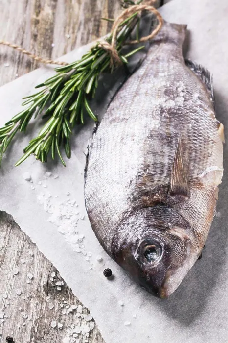 Framed Print : Raw dorado fish with rosemary and sea salt server on white paper over old wooden table Framed Print : Raw dorado fish with rosemary and sea salt server on white paper over old wooden table