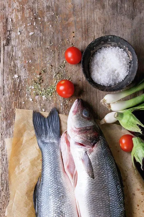 Framed Print : Two raw uncooked seebass fish on baking paper with sea salt