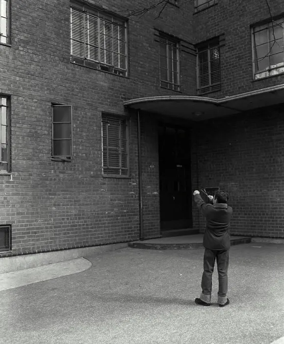 Framed Print : Rear view of a boy aiming at windows with a slingshot