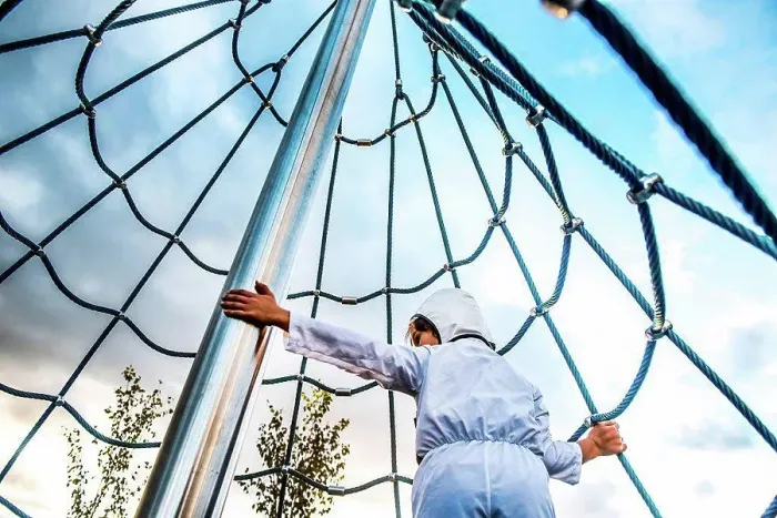 Framed Print : Rear view of boy in astronaut costume climbing up playground climbing frame Framed Print : Rear view of boy in astronaut costume climbing up playground climbing frame