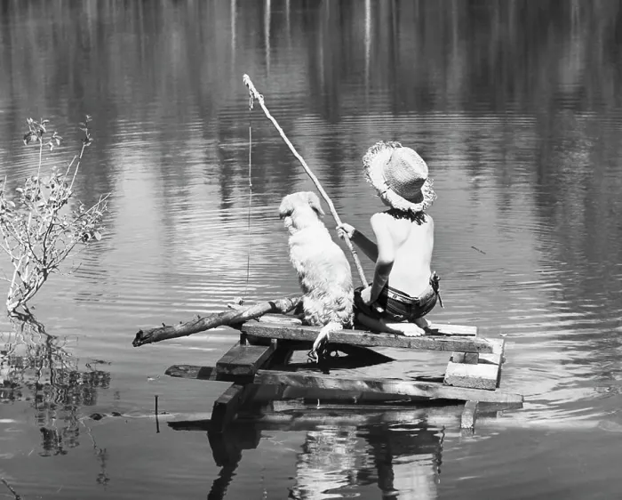 Framed Print : Rear view of a boy sitting with his dog and fishing in a lake Framed Print : Rear view of a boy sitting with his dog and fishing in a lake