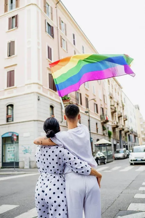 Framed Print : Rear view of young lesbian couple standing on a street, waving rainbow flag Framed Print : Rear view of young lesbian couple standing on a street, waving rainbow flag
