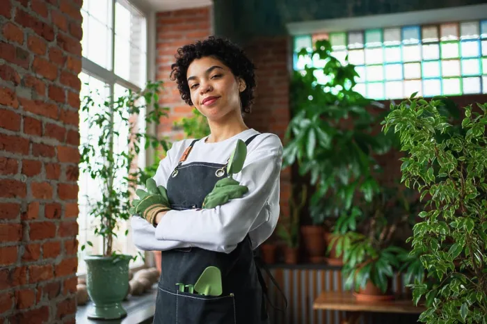 Framed Print : Running of own business. African woman florist wearing apron in botanical store with green plants Framed Print : Running of own business. African woman florist wearing apron in botanical store with green plants