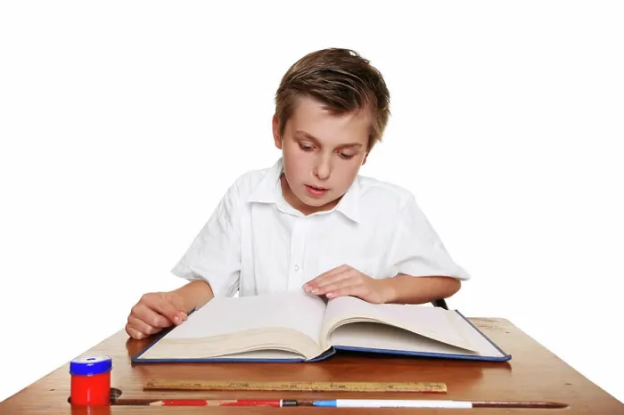 Framed Print : School student reading a book. A school child reading a book or studying Framed Print : School student reading a book. A school child reading a book or studying