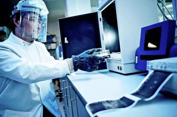 Framed Print : Scientist using equipment in lab