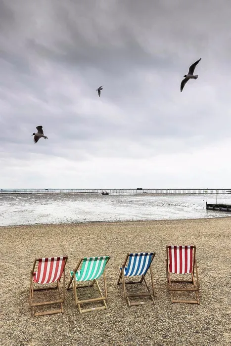Framed Print : Seagulls fly over empty deckchairs on Jubilee Beach in Southend on a cloudy day Framed Print : Seagulls fly over empty deckchairs on Jubilee Beach in Southend on a cloudy day