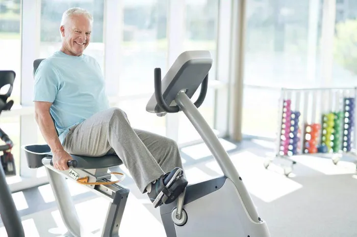 Framed Print : Senior man on static bike in the gym Framed Print : Senior man on static bike in the gym