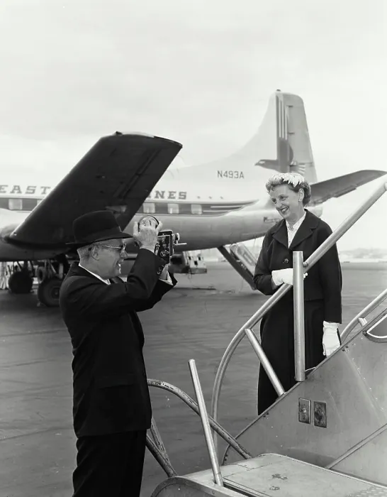 Framed Print : Senior man taking a picture of a senior woman at an airport Framed Print : Senior man taking a picture of a senior woman at an airport