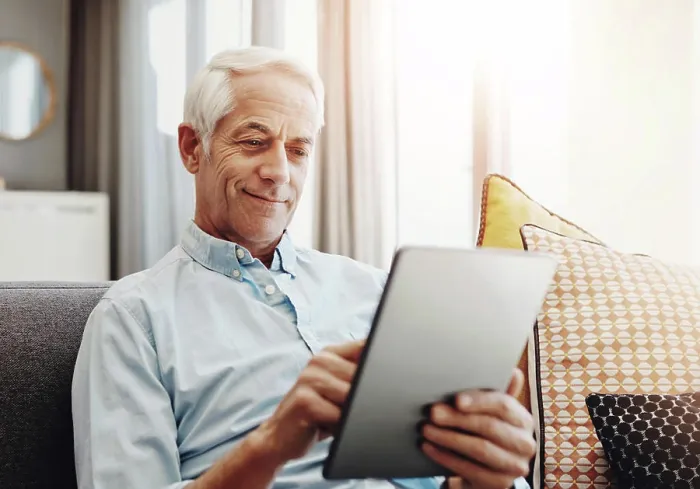 Framed Print : Senior man, technology and relax on sofa in home for typing email Framed Print : Senior man, technology and relax on sofa in home for typing email