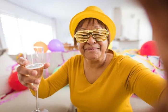 Framed Print : Senior woman in shutter glasses making video call while enjoying champagne during party at home