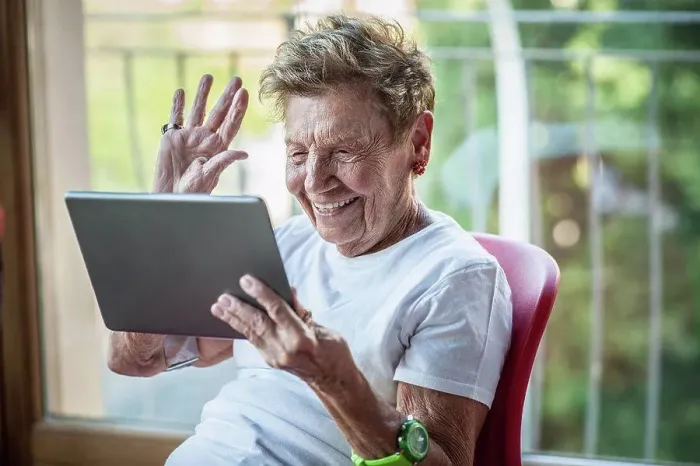 Framed Print : A very senior woman using digital tablet on apartment balcony Framed Print : A very senior woman using digital tablet on apartment balcony