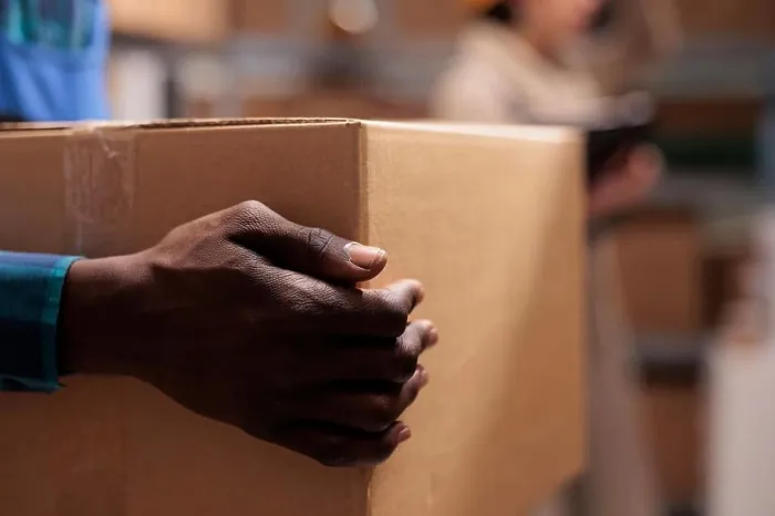Framed Print : Shipping service warehouse worker holding received parcel in hands Framed Print : Shipping service warehouse worker holding received parcel in hands