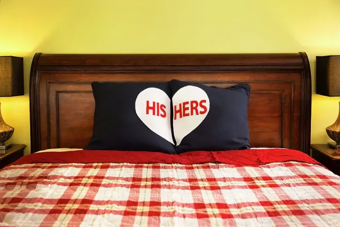 Framed Print : Detail shot of decorative His and Hers Pillows on dark wooden sleigh bed with red and white plaid comforter in master bedroom of home Framed Print : Detail shot of decorative His and Hers Pillows on dark wooden sleigh bed with red and white plaid comforter in master bedroom of home