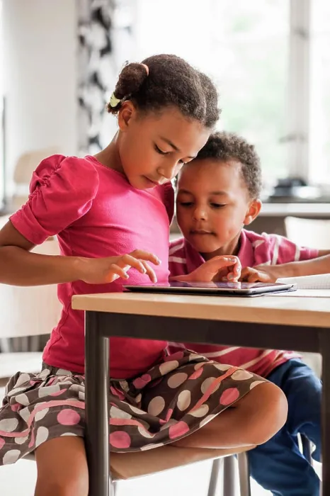 Framed Print : Siblings sharing a moment of discovery with a tablet at the kitchen table Framed Print : Siblings sharing a moment of discovery with a tablet at the kitchen table