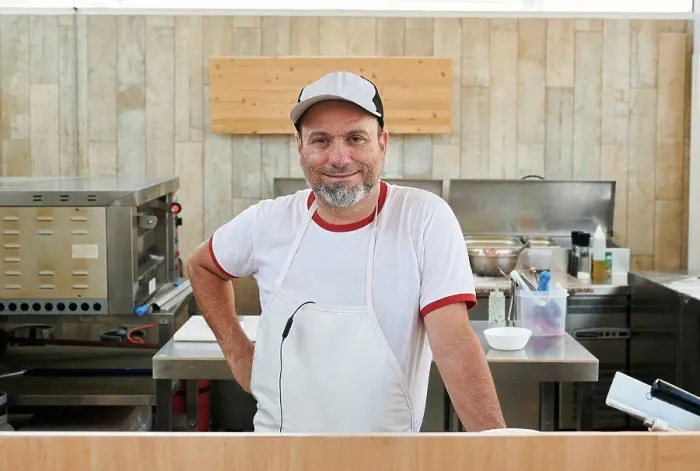 Framed Print : Small restaurant owner looks at the camera Framed Print : Small restaurant owner looks at the camera