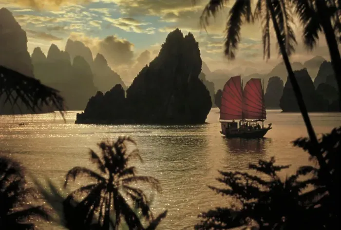 Framed Print : A small ship with red sales navigates through Halong Bay in Vietnam