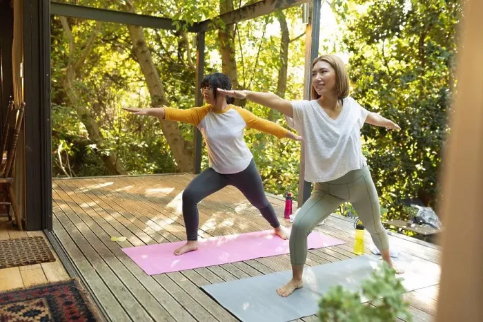 Framed Print : Smiling asian woman and her daughter practicing yoga on terrace in garden