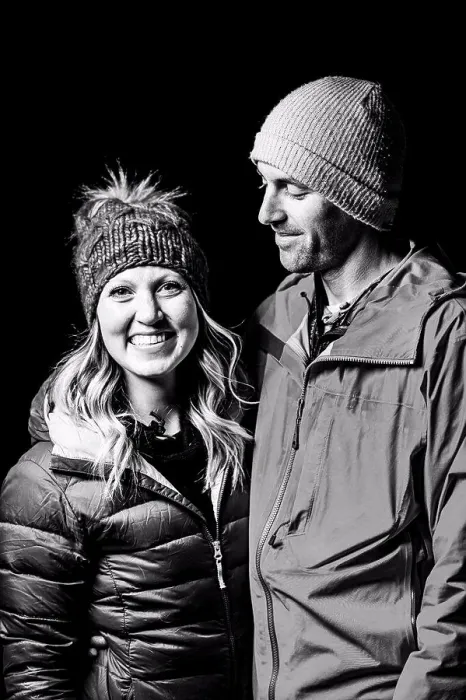Framed Print : Smiling couple in warm clothing standing against black background Framed Print : Smiling couple in warm clothing standing against black background