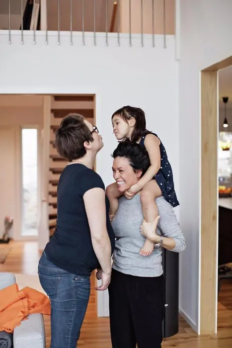 Framed Print : Smiling family enjoying while standing in living room at home Framed Print : Smiling family enjoying while standing in living room at home