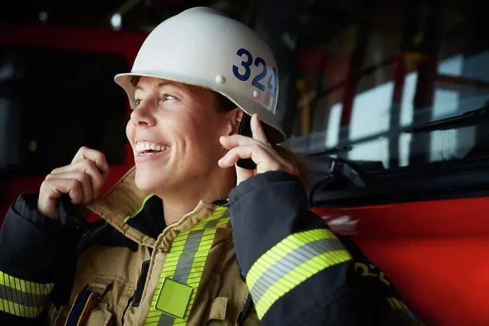 Framed Print : Smiling female firefighter wearing helmet at fire station Framed Print : Smiling female firefighter wearing helmet at fire station
