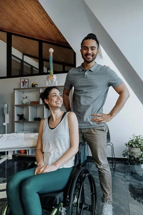 Framed Print : Smiling male physiotherapist standing while female patient sitting on wheelchair Framed Print : Smiling male physiotherapist standing while female patient sitting on wheelchair