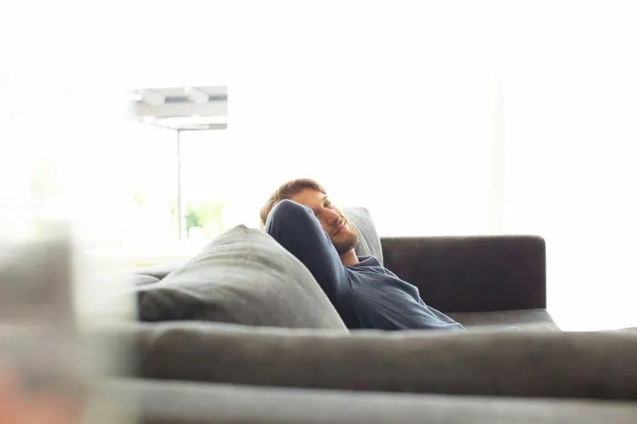 Framed Print : Smiling man relaxing on sofa