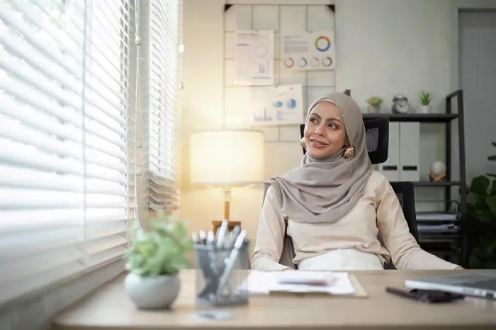 Framed Print : Smiling Muslim woman sitting at office desk Framed Print : Smiling Muslim woman sitting at office desk