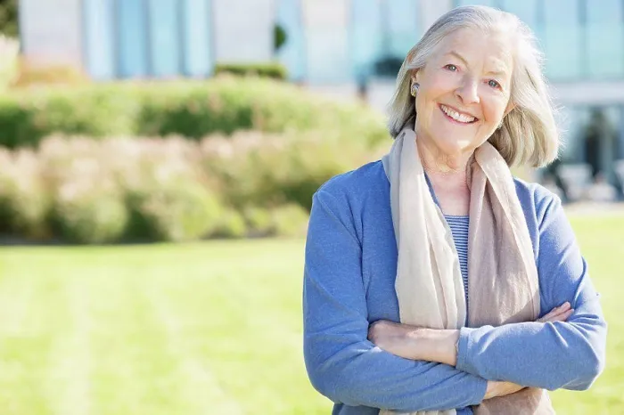 Framed Print : Smiling older woman standing outdoors, East Grinstead, UK