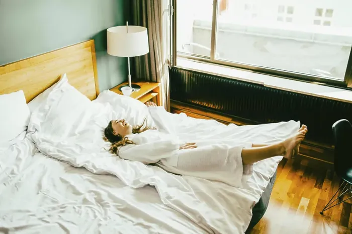 Framed Print : Smiling woman in bathrobe having fun on bed at hotel room Framed Print : Smiling woman in bathrobe having fun on bed at hotel room