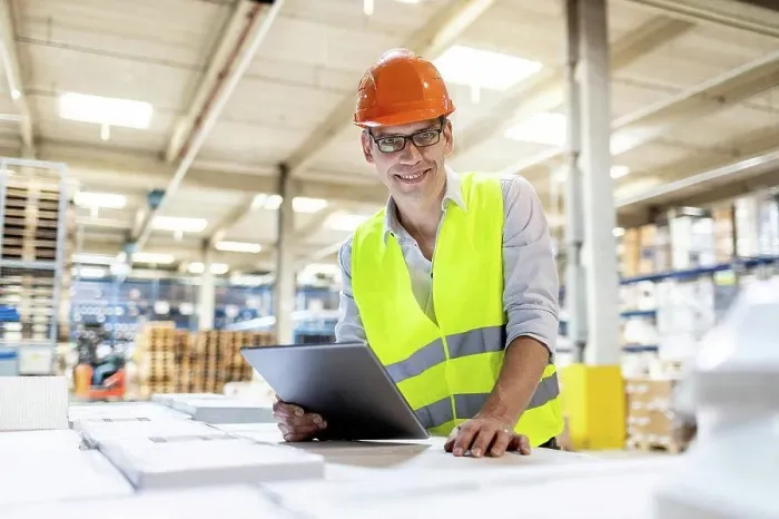 Framed Print : Smiling worker with tablet PC leaning on box in warehouse Framed Print : Smiling worker with tablet PC leaning on box in warehouse