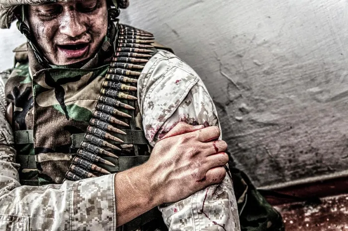 Framed Print : Soldier clamping his gunshot wound with healthy hand to try and stop bleeding Framed Print : Soldier clamping his gunshot wound with healthy hand to try and stop bleeding