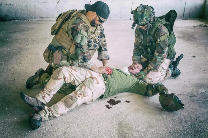 Framed Print : Soldiers giving emergency care to a wounded comrade lying on the floor, screaming in pain Framed Print : Soldiers giving emergency care to a wounded comrade lying on the floor, screaming in pain