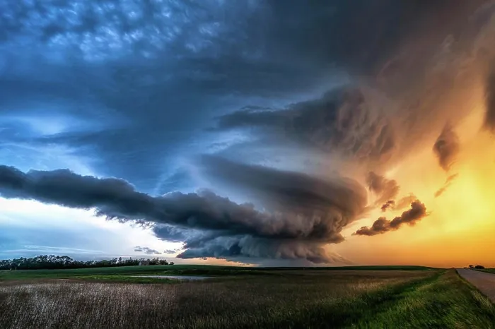 Framed Print : Spinning mesocyclone tornado warned storm over rural gravel road and field at sunset in Saskatechewan Canada