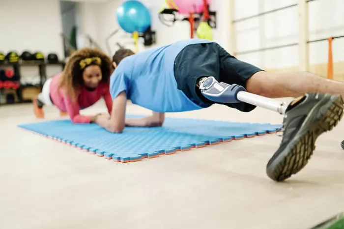 Framed Print : Sportsman with disability practicing plank position with friend on mat in gym Framed Print : Sportsman with disability practicing plank position with friend on mat in gym