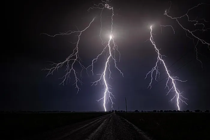 Framed Print : Storm with close range cloud to ground lightning flashing over old rural road in Kansas United States