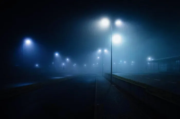 Framed Print : Street lamps illuminated over foggy, vacant road Framed Print : Street lamps illuminated over foggy, vacant road