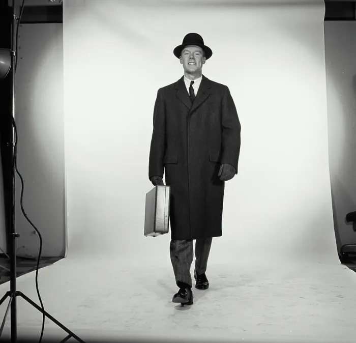 Framed Print : Studio portrait of businessman carrying briefcase Framed Print : Studio portrait of businessman carrying briefcase