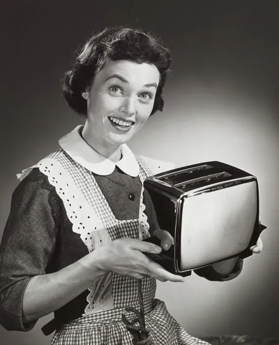 Framed Print : Studio shot of woman holding toaster Framed Print : Studio shot of woman holding toaster