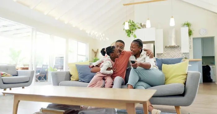 Framed Print : Support, black family on sofa and in living room of their home happy together smiling