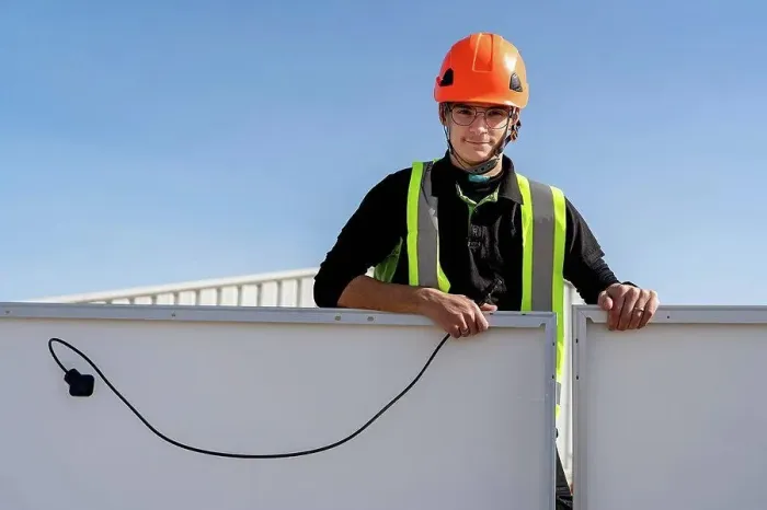 Framed Print : Technician with helmet standing by solar panel