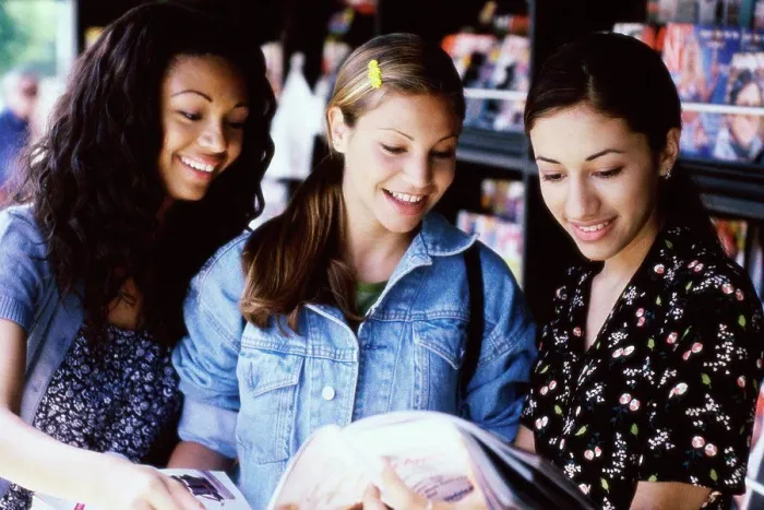 Framed Print : Three teenage girls reading a magazine