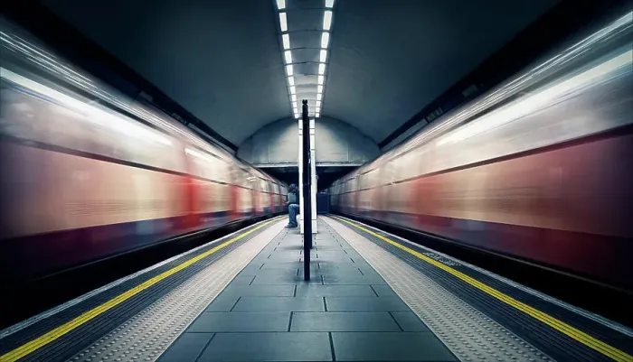 Framed Print : Two trains in motion and a seated commuter at London Tube Station