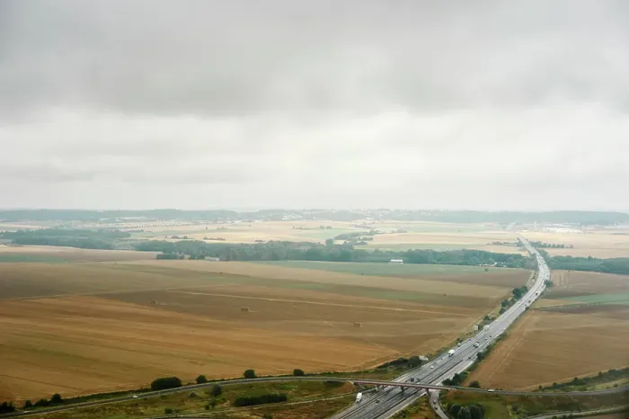 Framed Print : A tranquil aerial view of a highway slicing through the calm countryside under an overcast sky Framed Print : A tranquil aerial view of a highway slicing through the calm countryside under an overcast sky